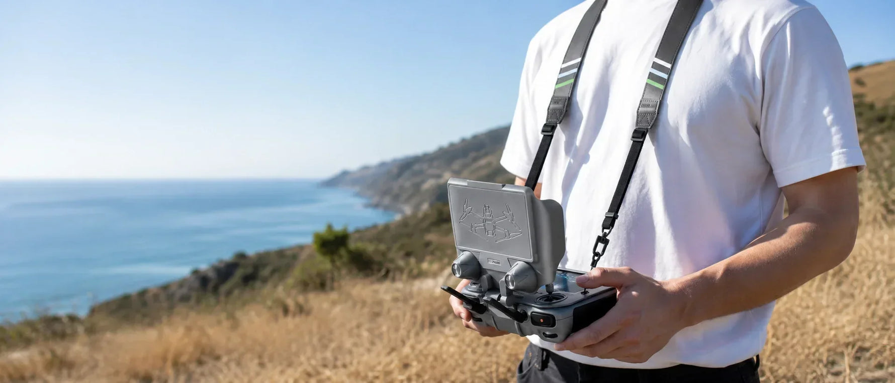 STARTRC 2-in-1 adjustable DJI RC sun hood with lanyard used outdoors to reduce screen glare and support hands-free controller handling.
