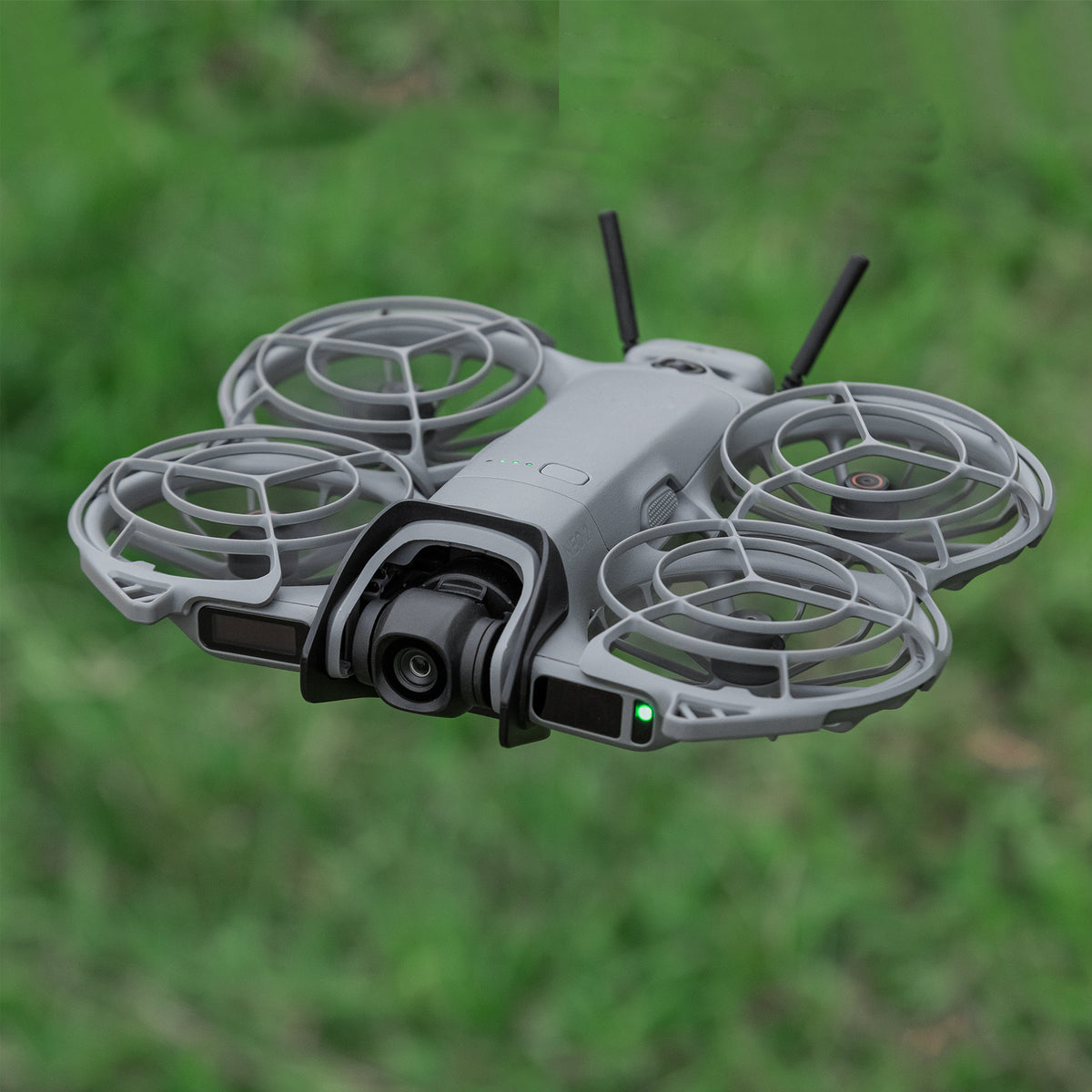 DJI Neo 2 flying outdoors over grass with the STARTRC gimbal bumper installed, adding no extra burden and staying secure without shaking.