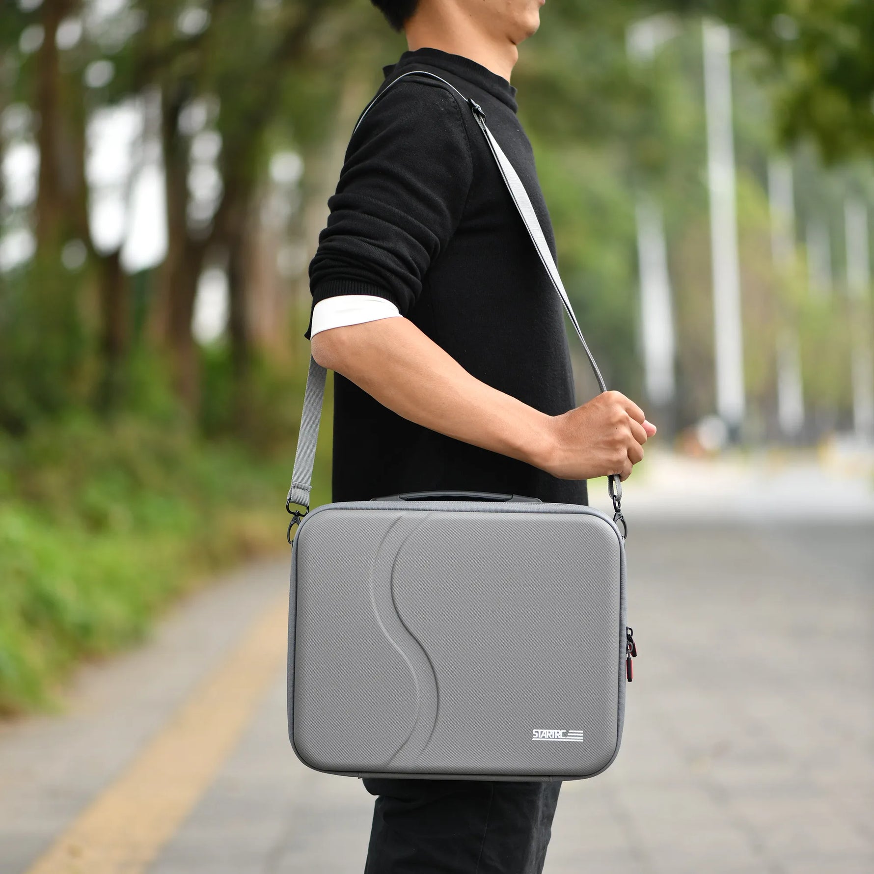 A man wearing the lightweight STARTRC DJI Neo 2 carrying case as a crossbody bag for hands-free outdoor travel.