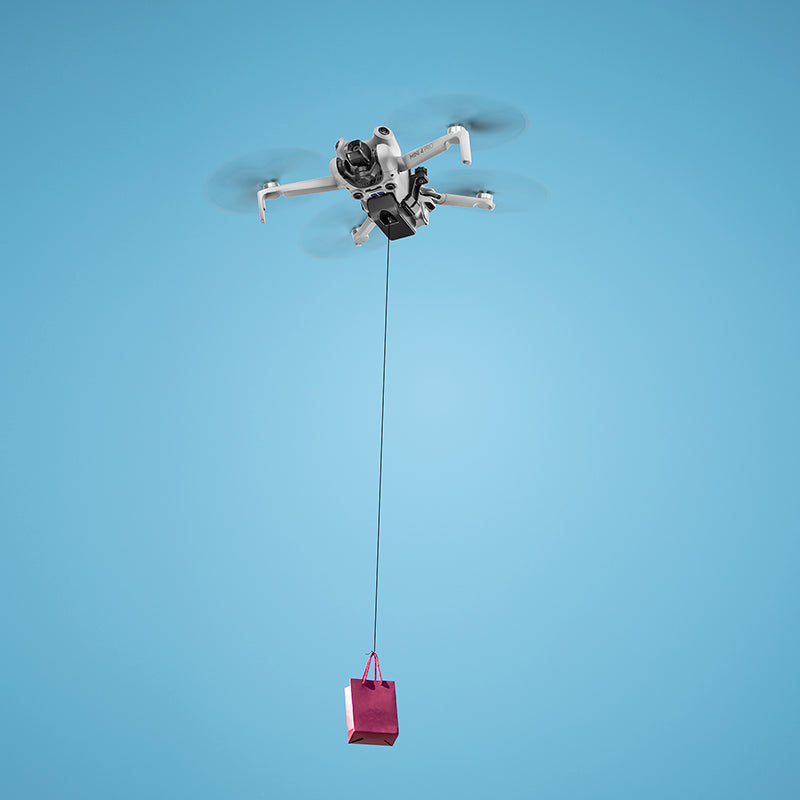Aerial view of a camera drone delivering a small payload mid-air, perfect for dropping wedding rings, fishing gear, or emergency supplies.