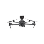 Front view of the drone securely fitted with the payload release accessory, maintaining perfect balance and flight stability.