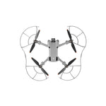 Top-down profile of a compact camera drone with full enclosure prop guards attached, preventing blade bending and motor strain.