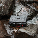 The rugged STARTRC carrying case sitting securely on wet outdoor rocks, demonstrating its IP67 waterproof and weather-resistant capabilities for adventure filmmakers.