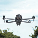 DJI Mavic 4 Pro flying outdoors equipped with the 110-degree wide-angle lens accessory, capturing broader landscapes and cityscapes with accurate color reproduction.