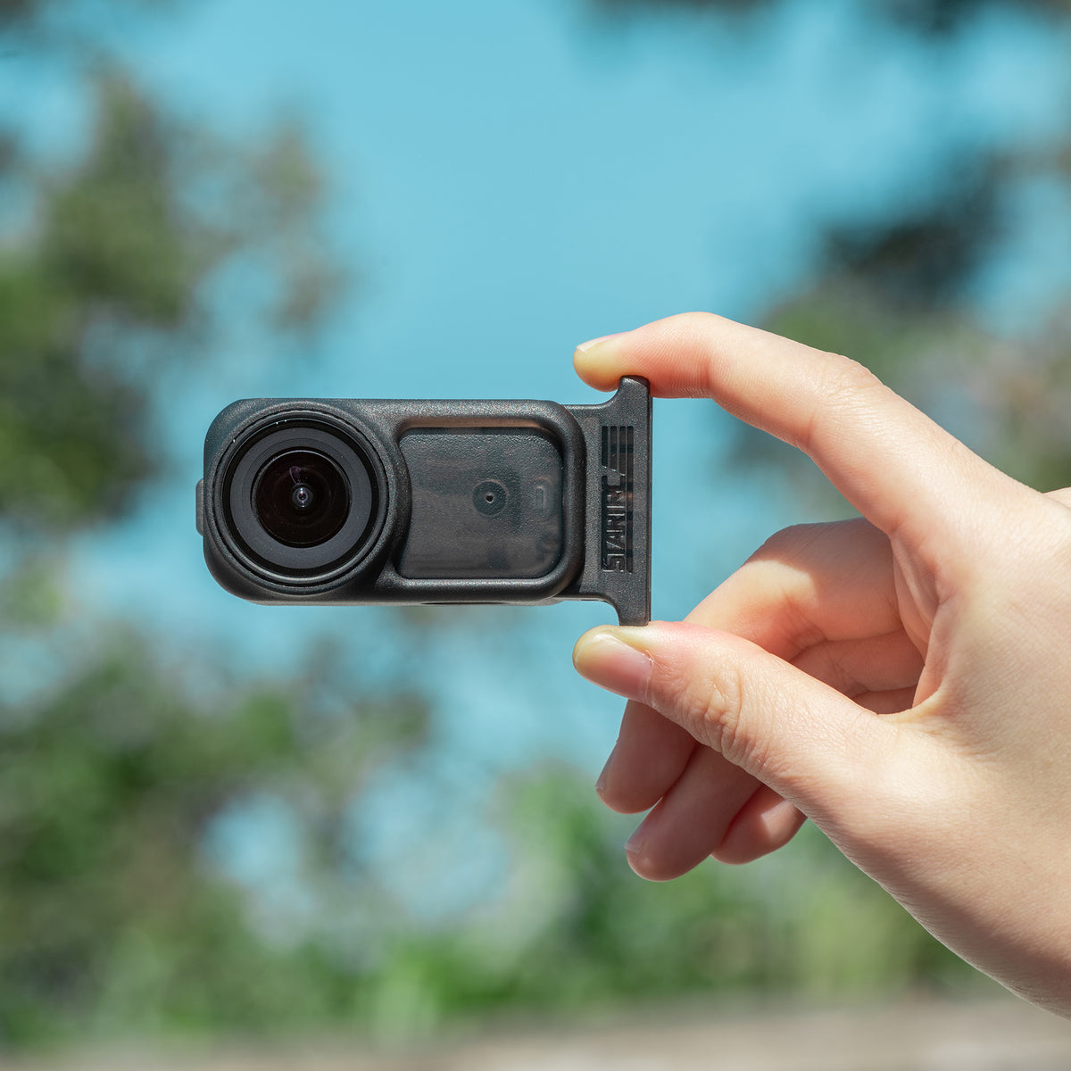 User holding the DJI Osmo Nano horizontally with the STARTRC frame attached, demonstrating its sleek and minimalist profile that stays completely out of the shot.