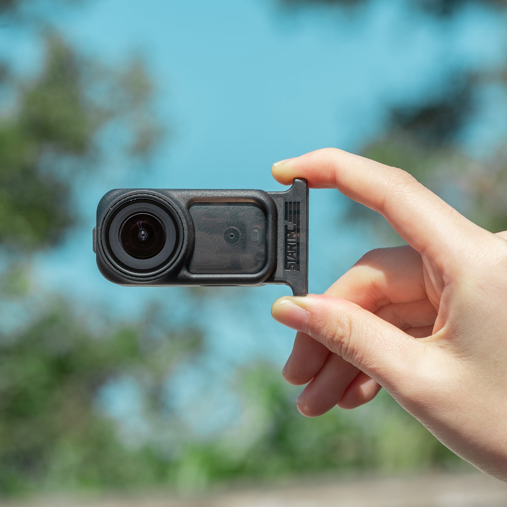User holding the DJI Osmo Nano horizontally with the STARTRC frame attached, demonstrating its sleek and minimalist profile that stays completely out of the shot.