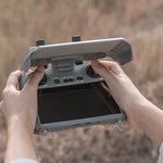 Drone pilot holding the remote controller with the UV-blocking sun hood attached, adapting easily to variable outdoor lighting conditions.