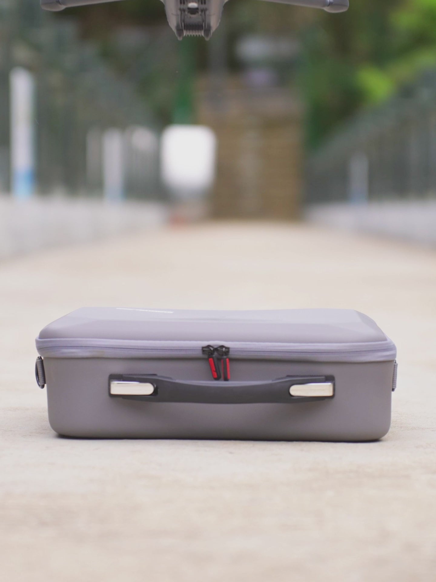 Video thumbnail featuring the rugged carrying case for DJI Mavic 4 Pro resting safely on an outdoor path during a travel vlog.