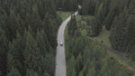 A scenic aerial view of a car driving through a forest, demonstrating the ideal travel scenario for transporting your gear with the STARTRC DJI Avata 360 case.