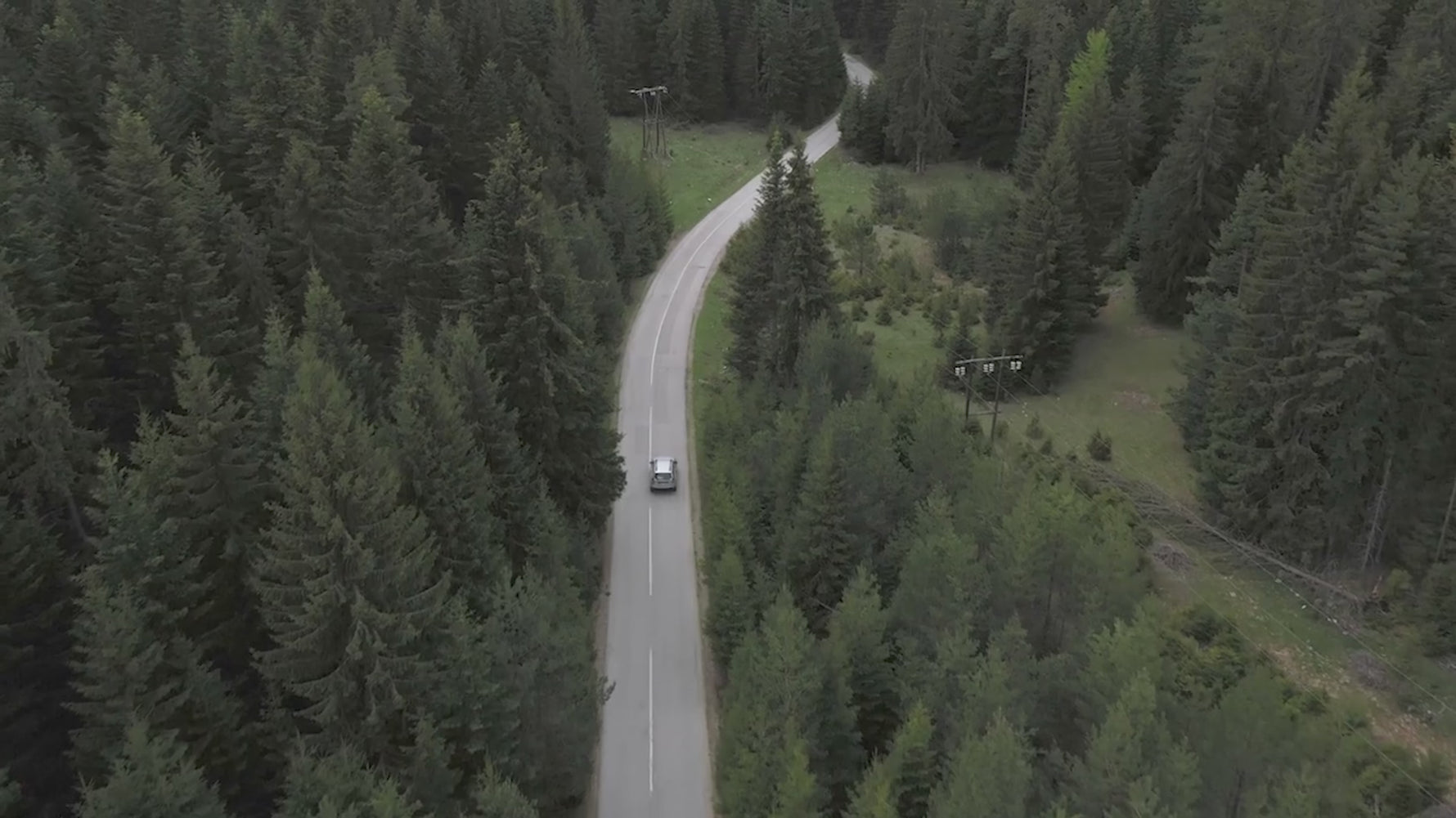 A scenic aerial view of a car driving through a forest, demonstrating the ideal travel scenario for transporting your gear with the STARTRC DJI Avata 360 case.