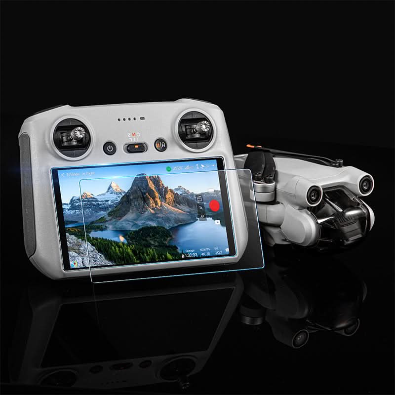 Crystal clear landscape view on the DJI RC2 controller display protected by the 9H hardness glass, shown next to a folded camera drone.