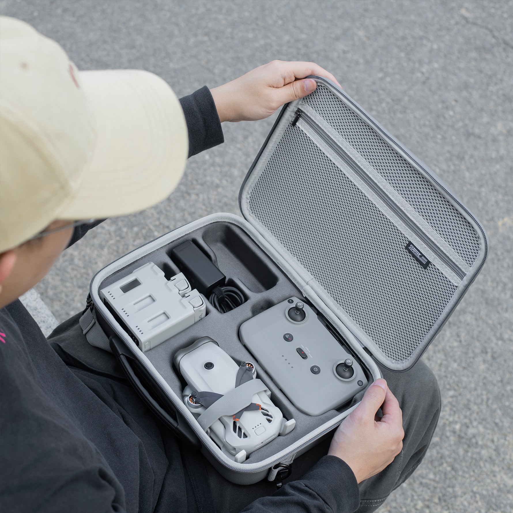 Opening the STARTRC DJI Lito storage bag outdoors to access the drone and accessories. Reliable protection for your DJI Lito 1 whether on location or at home.
