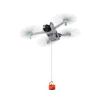 DJI Mini series drone equipped with a universal airdrop system, utilizing 10-second precision drop technology to deliver a red gift box mid-air.