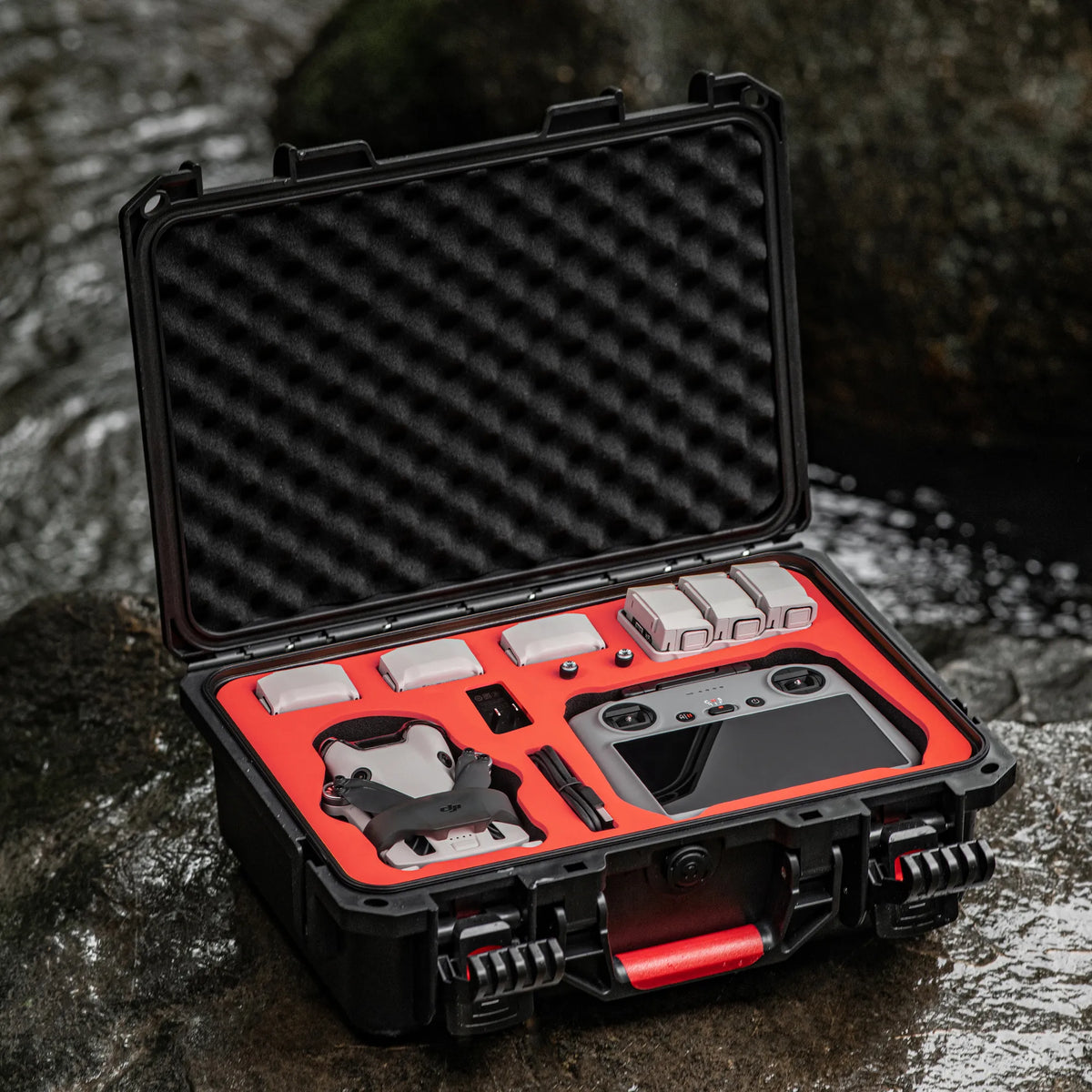 The shockproof drone hard case resting safely on wet river rocks, tested by professional aerial filmmakers for real-world durability.