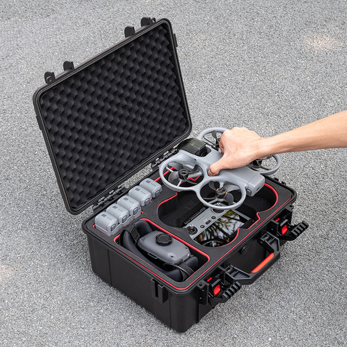 A pilot easily removing the DJI Avata 360 from the hard case without detaching the gimbal guard, ready for quick flight.
